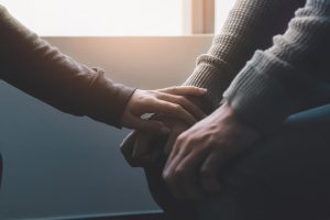 person holding the hand of a New York rape victim